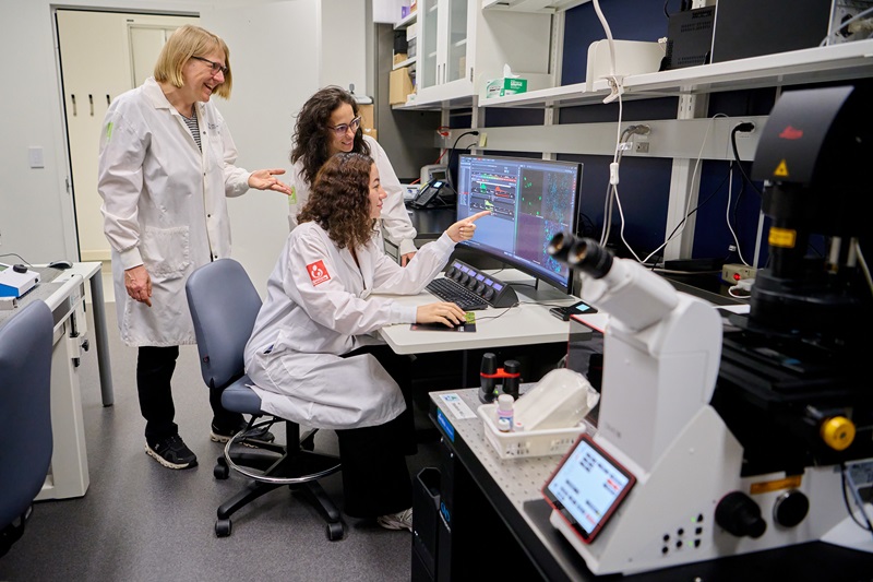 Elke et Vanesa aident une usagère de la plateforme de microscopie